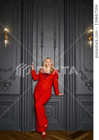 Stylish woman exuding confidence near intricate wall decor during night 139667504