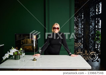 Sophisticated woman at marble island with luxurious decor details Sophisticated woman at marble island with luxurious decor details 139667548