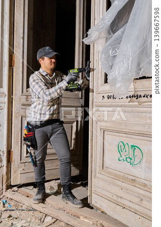 Caucasian preservationist assessing graffiti on historic door 139667598