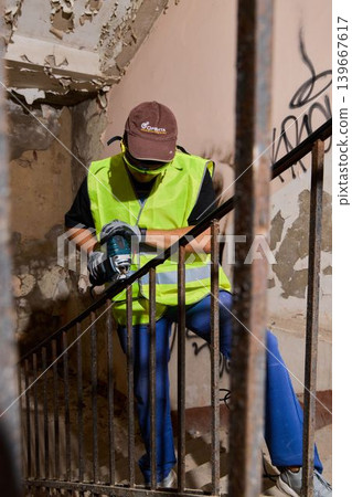 Construction worker focused on grinding metal amidst dusty surroundings Construction worker focused on grinding metal amidst dusty surroundings 139667617