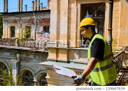 Architect examines ancient blueprints and stone craftsmanship carefully 139667634
