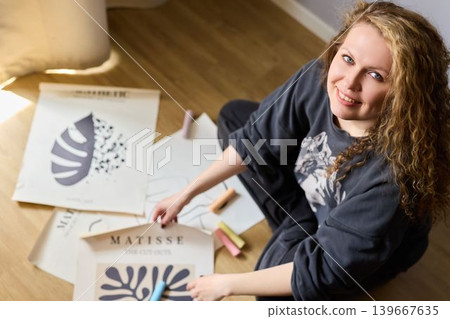 White gallery curator arranging matisse prints for exhibit 139667635
