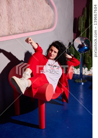 White woman brand ambassador kicking feet up on red chair White woman brand ambassador kicking feet up on red chair 139667684