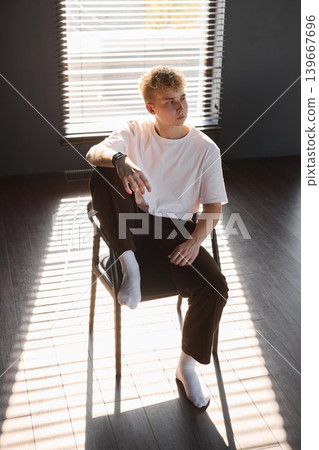 Person wearing white relaxes peacefully in glowing environment Person wearing white relaxes peacefully in glowing environment 139667696