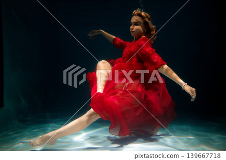 Seductive underwater allure in vibrant crimson attire with fins Seductive underwater allure in vibrant crimson attire with fins 139667718