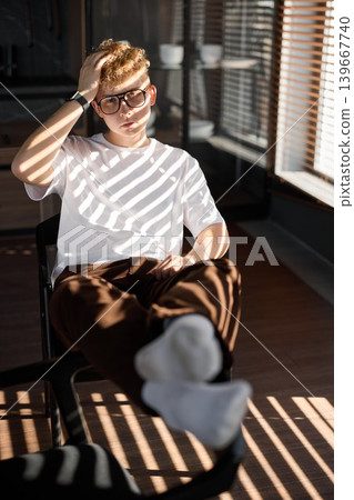 Relaxed office environment captured with young man enjoying leisure Relaxed office environment captured with young man enjoying leisure 139667740
