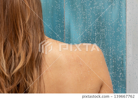Close up woman showering from back, water drops splashing on wet skin and hair, performing daily hygiene routine in a bathroom, feeling clean and fresh under falling water Close up woman showering from back, water drops splashing on wet skin and hair, performing daily hygiene routine in a bathroom, feeling clean and fresh under falling water 139667762