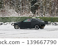 Coupe slides across snow generating sparks and cold forest backdrop 139667790