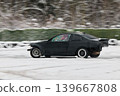 Dynamic black coupe navigating snowy terrain with style 139667808