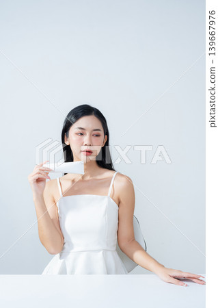 Asian woman holding product isolated on white background for promotion advertising. Asian woman holding product isolated on white background for promotion advertising. 139667976