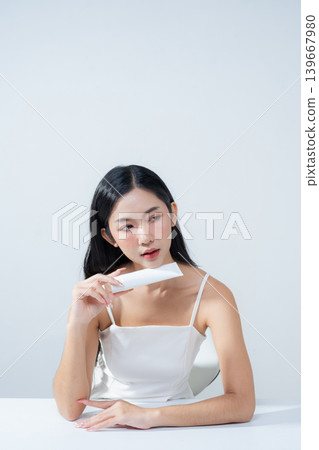 Asian woman holding product isolated on white background for promotion advertising. Asian woman holding product isolated on white background for promotion advertising. 139667980