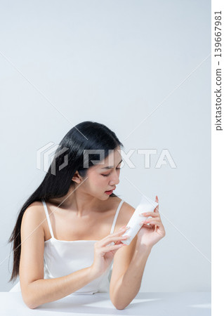 Asian woman holding product isolated on white background for promotion advertising. Asian woman holding product isolated on white background for promotion advertising. 139667981