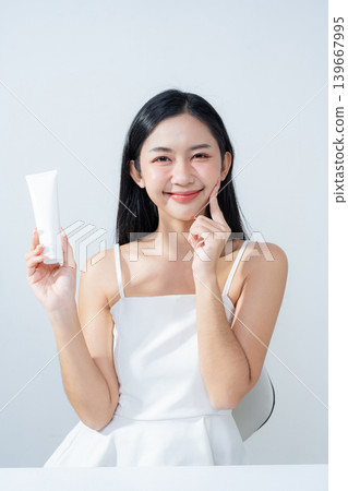 Asian woman hold product and looking to camera, isolated on white background. Asian woman hold product and looking to camera, isolated on white background. 139667995