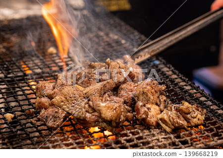Grilled chicken thighs in a basket: A chicken dish grilled over charcoal for a fragrant finish. 139668219