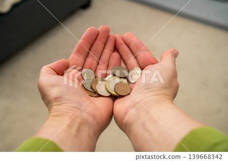 Hands holding coins, financial hardship budgeting money shortage and personal finance concept 139668342