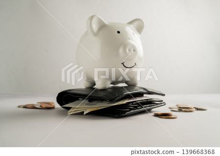 Piggy bank on wallet with cash money and coins, savings personal finance budgeting and money management concept Piggy bank on wallet with cash money and coins, savings personal finance budgeting and money management concept 139668368