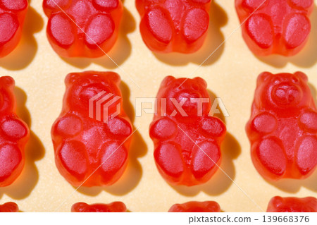 Jelly gummy bears flat lay, fruit vitamins on bright background, food supplements.Orange vitamins on yellow background, macro photography Jelly gummy bears flat lay, fruit vitamins on bright background, food supplements.Orange vitamins on yellow background, macro photography 139668376