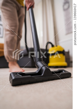 Vacuuming the floor. Close up of vacuum cleaner, living room. Household and useful technology lifestyle. Copy space Vacuuming the floor. Close up of vacuum cleaner, living room. Household and useful technology lifestyle. Copy space 139668417