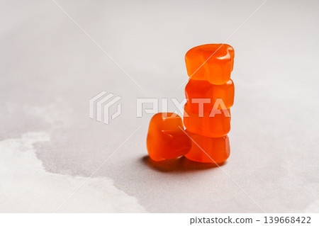 Jelly gummy fruit vitamins, food supplements.Orange vitamins on bright background with copy space Jelly gummy fruit vitamins, food supplements.Orange vitamins on bright background with copy space 139668422