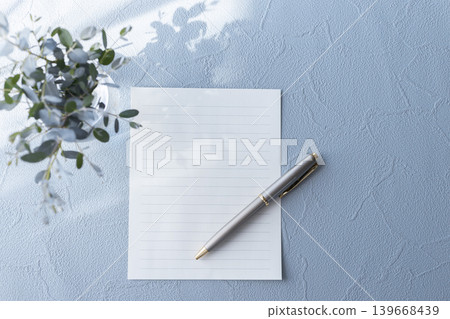 A natural letter image with stationery and a pen against a blue background. 139668439
