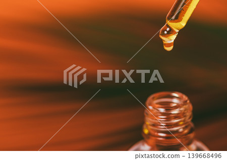 Essential oil drips slowly from dropper into bottle Essential oil drips slowly from dropper into bottle 139668496