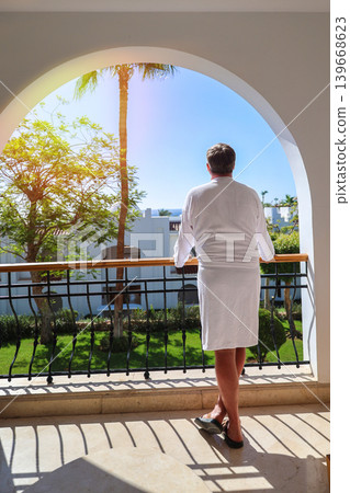 Man standing on balcony admiring the beauty of nature, enjoying the tranquility of the outdoors, view from back Man standing on balcony admiring the beauty of nature, enjoying the tranquility of the outdoors, view from back 139668623