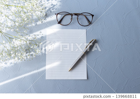 A natural letter image featuring baby's breath, stationery, and glasses. A natural letter image featuring baby's breath, stationery, and glasses. 139668811