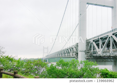 The magnificent Seto Ohashi Bridge stretches across the sky under a cloudy sky. The magnificent Seto Ohashi Bridge stretches across the sky under a cloudy sky. 139668962