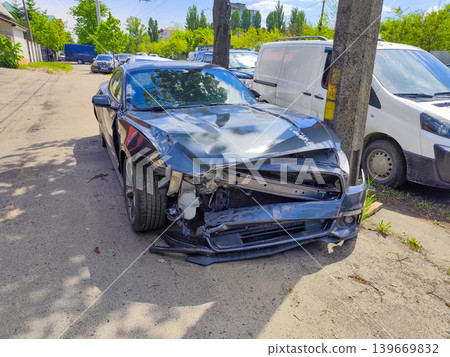 Smashed Front End of a Grey Sports Car After Collision With a Utility Pole on a City Street Smashed Front End of a Grey Sports Car After Collision With a Utility Pole on a City Street 139669832
