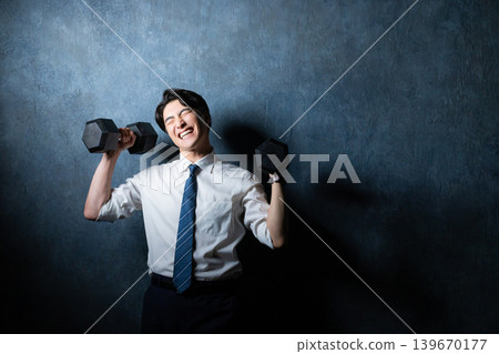 A businessman with a dumbbell A businessman with a dumbbell 139670177