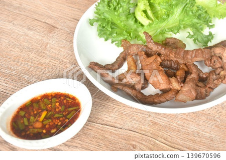 fried crispy salty fermenting beef fat meat with pepper on plate dipping Thai spicy chili tamarind sauce 139670596