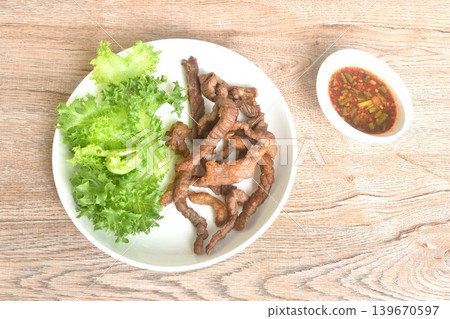 fried crispy salty fermenting beef fat meat with pepper on plate dipping Thai spicy chili tamarind sauce 139670597
