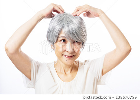 A senior woman with white hair receiving a head massage. A senior woman with white hair receiving a head massage. 139670759
