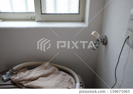A water tap (faucet) with the washing machine hose removed. A water tap (faucet) with the washing machine hose removed. 139671065