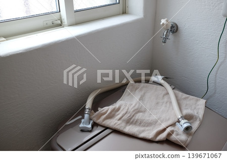 A water tap (faucet) with the washing machine hose removed. A water tap (faucet) with the washing machine hose removed. 139671067