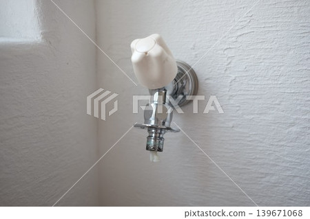 A water tap (faucet) with the washing machine hose removed. A water tap (faucet) with the washing machine hose removed. 139671068