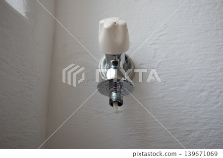 A water tap (faucet) with the washing machine hose removed. A water tap (faucet) with the washing machine hose removed. 139671069