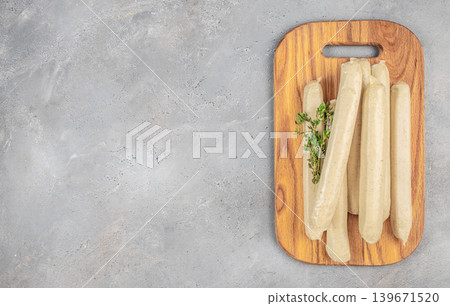 Raw white sausages on wooden cutting board top view Raw white sausages on wooden cutting board top view 139671520