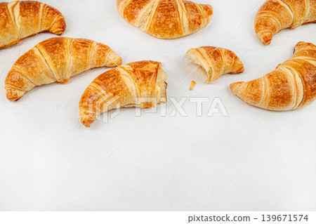 Fresh croissants with bitten pastry on white background, breakfast food banner with copy space Fresh croissants with bitten pastry on white background, breakfast food banner with copy space 139671574