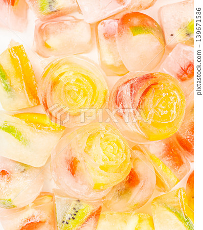 Frozen fruit ice cubes background with strawberry kiwi and citrus slices top view 139671586