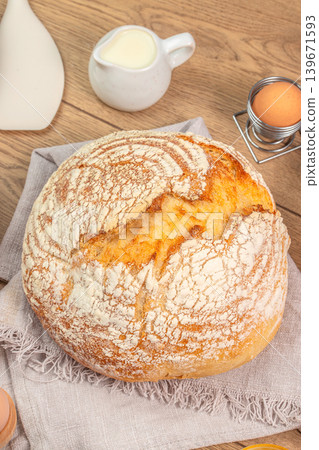 Artisan sourdough bread loaf with milk and eggs on wooden table top view Artisan sourdough bread loaf with milk and eggs on wooden table top view 139671593