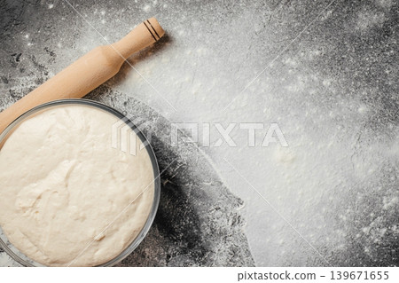 Fermented sourdough dough with rolling pin on flour covered rustic background for bakery advertising 139671655
