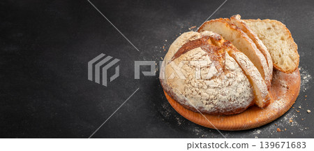 Sliced artisan sourdough bread on dark rustic background with copy space for bakery advertising Sliced artisan sourdough bread on dark rustic background with copy space for bakery advertising 139671683