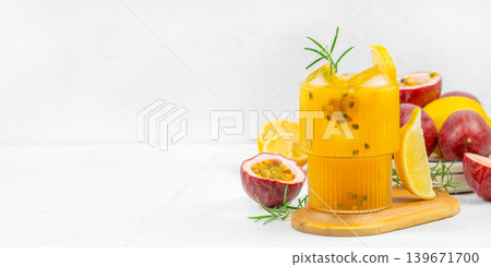 Passion fruit mango lemonade cocktail with rosemary and citrus on light background with copy space Passion fruit mango lemonade cocktail with rosemary and citrus on light background with copy space 139671700