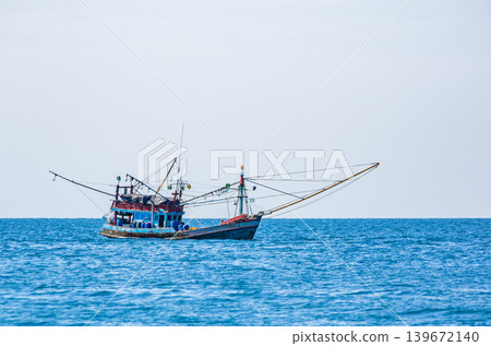 Colorful Traditional Thai Fishing Trawler with Thai Flags on Open Sea in Gulf of Thailand Colorful Traditional Thai Fishing Trawler with Thai Flags on Open Sea in Gulf of Thailand 139672140