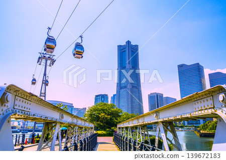 Yokohama cityscape in Japan: Yokohama Air Cabin, Sakuragicho Station (back left), the Kishamichi promenade surrounded by fresh greenery, and Yokohama Landmark Tower. Yokohama cityscape in Japan: Yokohama Air Cabin, Sakuragicho Station (back left), the Kishamichi promenade surrounded by fresh greenery, and Yokohama Landmark Tower. 139672183