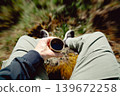 Man holding plastic cup of coffee in forest. Outdoor caffeine boost break with blurred nature background, energy and lifestyle concept 139672258