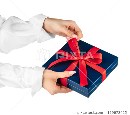 Gift box with red ribbon in female hands isolated background with copy space Gift box with red ribbon in female hands isolated background with copy space 139672425