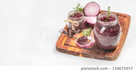 Red onion jam in glass jars with fresh onion and herbs on wooden board copy space 139672457