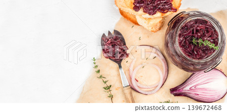 Onion jam in glass jar with bread and ingredients on light background with copy space top view 139672468